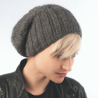 A woman wearing an Oversized Cable Merino Slouch hat.