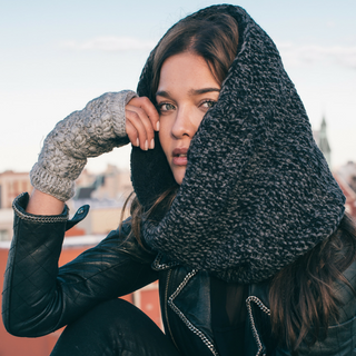 A woman wearing Flower Crochet Handwarmers and a black jacket, ideal for incorporating into product descriptions.