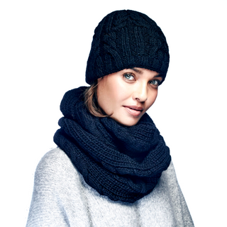 A woman wearing a Trinitas Infinity Scarf, merino wool infinity scarf and hat.