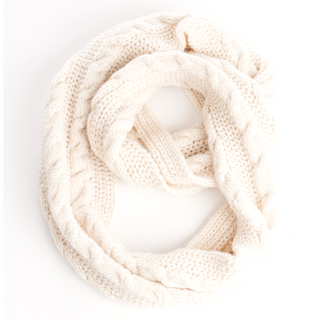 A cream-colored Trinitas Infinity Scarf handmade in Nepal merino wool arranged in a loop on a white background.