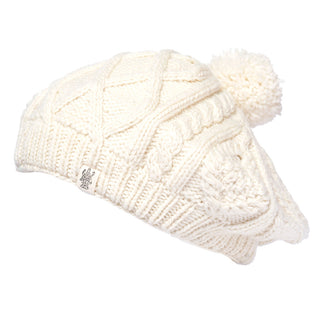 A white handmade Yves Beret beanie with a pom pom.