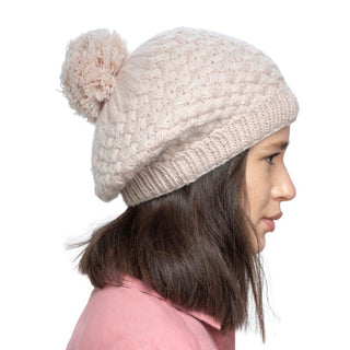 A girl wearing a handmade Bliss Beret with a pom pom.
