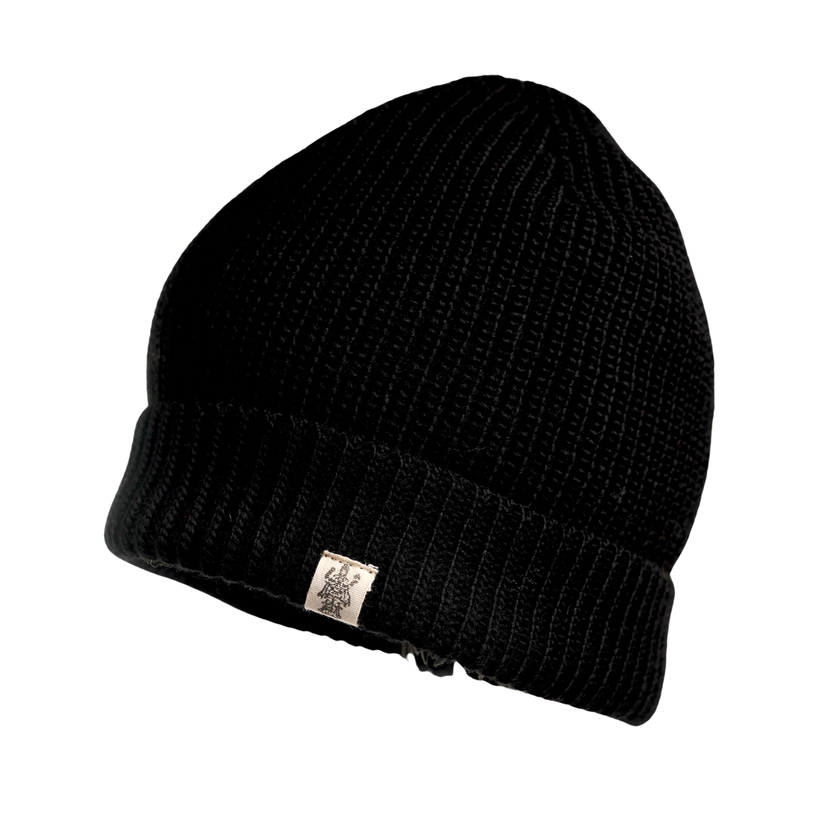 The Hand Knit Bond Hat is a black ribbed knit beanie with a folded brim and a small rectangular white tag sewn onto the brim, featuring a simple graphic design or logo. Reminiscent of a classic hand-knit hat, this beanie is displayed on a plain white background.