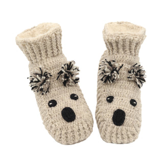 A pair of knitted koala slippers with pom poms.