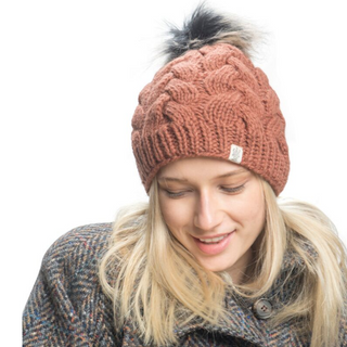 A woman wearing a Boheme Cable Beanie with Faux Fur Pom.