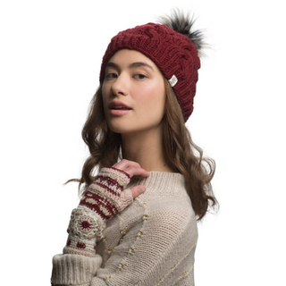 A woman wearing a Boheme Cable Beanie with Faux Fur Pom and gloves.