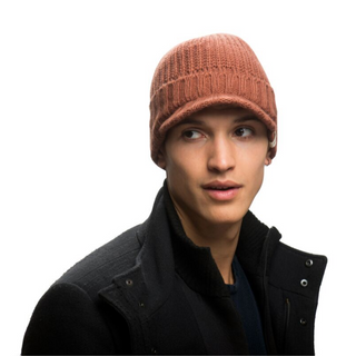 A young individual wearing a Merino Wool Fillmore Cap Visor and a black jacket, looking to the side with a neutral expression, isolated on a white background.