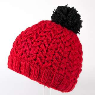 A red handmade Black Pom Beanie, knitted from merino wool.