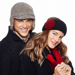 Two smiling individuals wearing winter accessories such as Detachable Flower Headband w/ Button hats and a scarf handmade in Nepal.