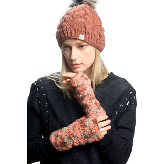 A woman wearing handmade knitted gloves and a Boheme Cable Beanie with Faux Fur Pom.