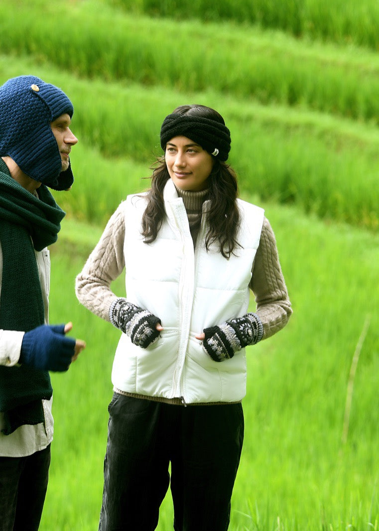 Woman in patterned fingerless gloves and a knit headband in rice terraces