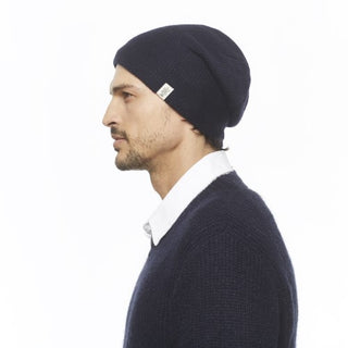A man wearing a navy beanie, sweater, and The Depp Slouch leather boots.