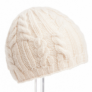 A Borderline Cable Knit Beanie handmade in Nepal displayed on a stand against a white background.