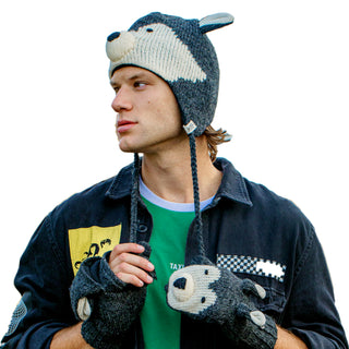 A young man wearing a whimsical Wolf Hat and matching gloves, all hand-knit from 100% wool, looks off to his right.