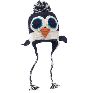 Hand-made in Nepal, crochet penguin-themed hat with ear flaps and tassels on a white background.