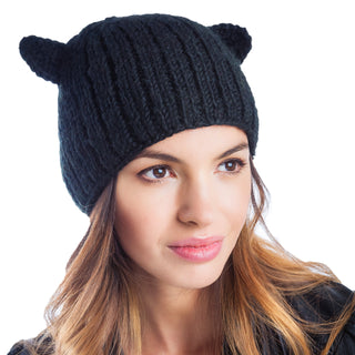 A woman with light skin and long hair wearing a black Cat Ear Beanie looks to the side against a white background.