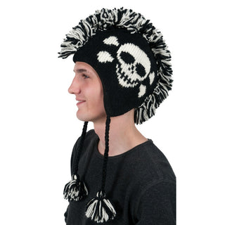 A person wearing a black and white Skull Mohawk beanie, handmade in Nepal.