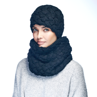 A person wearing a chunky knitted black beanie and a matching thick merino wool Holden Neckwarmer, posing against a plain background.