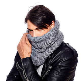A man with dark hair wearing a black leather jacket and a chunky grey Popcorn Snood covering his lower face.