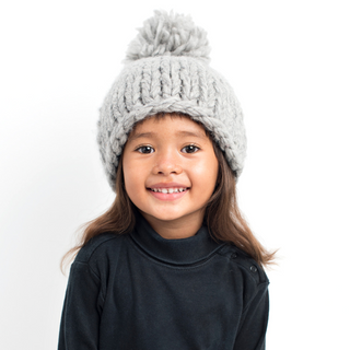 A girl wearing a Chunky Beanie w/ Pom hat.