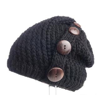 A black Four Button Knit Beret Cap displayed against a white background, handmade in Nepal.