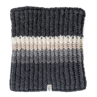 A Hi Fidelity Neckwarmer with horizontal stripes in shades of black, gray, and cream, featuring a ribbed texture and a small label at the lower edge, handmade in Nepal.