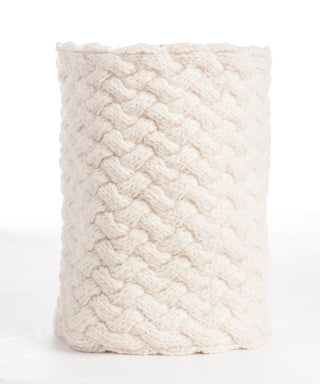 A cream-colored merino wool Holden Neckwarmer forming a cylindrical shape, suggesting a cozy, textured sleeve or covering, handmade in Nepal.