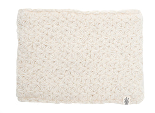 A beige merino wool textured cushion with a pattern of raised, woven geometric shapes, isolated on a white background.