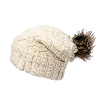 A handmade white Hope Slouch beanie with a fur pom and a knit cable design.