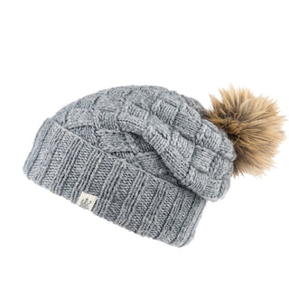 A grey, handmade knitted Hope Slouch with a fur pom pom.