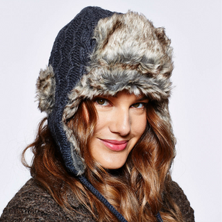 A woman wearing a Cable Knit Russian Hat with Faux Fur lining.