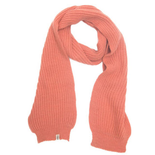 The Laurent Scarf, a hand-knitted ribbed piece in solid muted orange merino wool, is displayed on a white background with a small fabric tag attached near one edge.