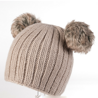 A beige ribbed knit Double Pom Beanie, with two fluffy faux fur poms attached to the top, displayed against a white background.