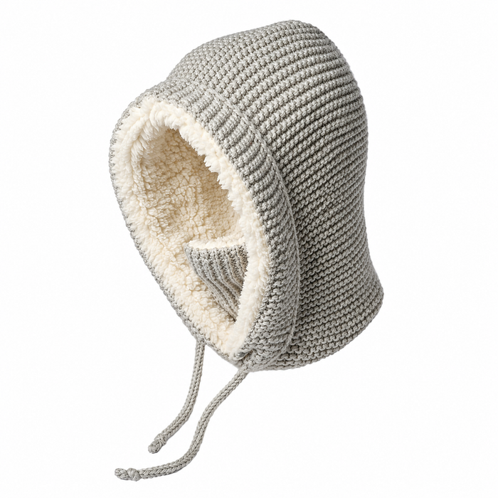 A Hand Knit Glide Hood in gray lambswool with a seed-stitch texture, featuring cream-colored fleece lining and two drawstrings, designed to keep the head and neck warm. Shown against a white background.
