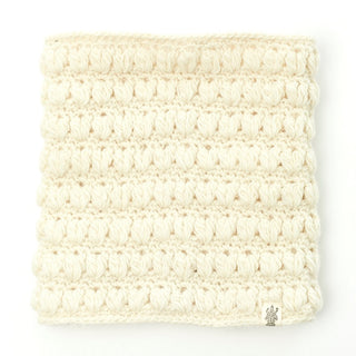 A cream-colored crocheted Good Vibes Neckwarmer, handmade in Nepal, with a textured pattern on a white background.