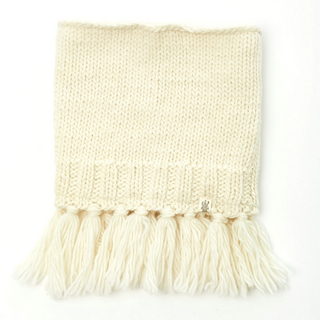 A cream-colored knitted Sweet Emotions Neckwarmer with tassels on one edge and a sherpa fleece lining, displayed against a white background.