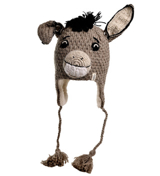 The Donkey Hat is a hand-crocheted accessory designed to look like a donkey's head, featuring eyes, a nose, and a smiling mouth. It includes two ears, string tassels hanging from each side, and is primarily gray with black yarn detailing on the donkey's mane.