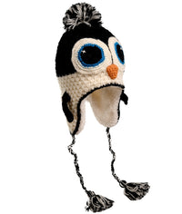 The Hand Crochet Penguin Hat is an adorable wool hat featuring classic black-and-white coloring, large blue eyes, a small orange beak, ear flaps, and braided tassels with pom-poms at the ends—perfect for cozy and cute winter adventures!.