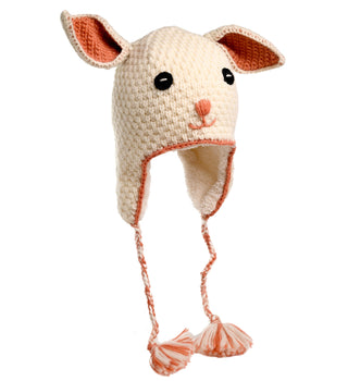 The Crochet Rabbit Hat is a cream-colored, handmade knitted hat from Nepal, designed to resemble a rabbit with large ears, black eyes, a small nose, and two braids hanging from the ear flaps that each end with two tassels. The inner parts of the ears and the braids are lined with pink.