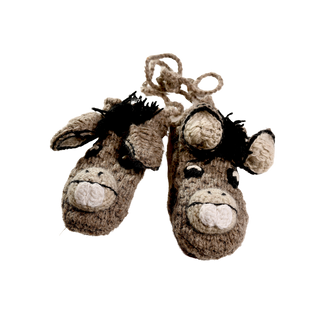 A pair of Crochet Donkey Mittens featuring adorable smiling faces, floppy ears, and black yarn tufts for manes. These sherpa-lined mittens are connected by a string and are primarily brown with beige and black accents. Handmade in Nepal, these cozy treasures offer unparalleled warmth and comfort for tiny hands.