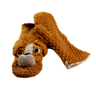 The Crochet Lucy Puppy Mittens are a pair of handmade brown knitted mittens from Nepal, featuring an adorable dog's face design on one mitten, complete with eyes and a snout. Lined with sherpa for extra warmth, these mittens are perfect for chilly days. The background is plain black.