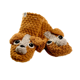 The Crochet Lucy Puppy Mittens are a pair of orange, handmade wool mittens from Nepal, designed to resemble dog faces. Each mitten features large, expressive eyes, a brown nose, and floppy ears made from the same yarn. The sherpa-lined mittens are placed side by side on a plain background.