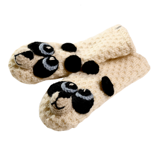 A pair of cream-colored, crocheted mittens featuring black and white panda faces on the fingertips and black spots along the hand area, meticulously hand-made in Nepal, showcased against a black background.