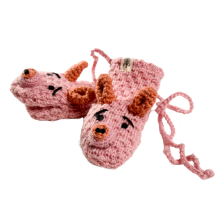 A pair of Crochet Piggy Mittens, handmade in Nepal, featuring a charming design that resembles pig faces with brown ears, black eyes, and snouts. The pink crocheted baby mittens are connected by a string.