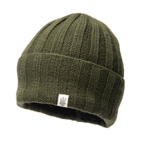 The Hand Loom Ribbed Beanie in olive green features a ribbed knit design with a folded brim and a small white rectangular logo tag on the front. Crafted from cozy merino wool, this stylish beanie offers both warmth and comfort, presented here against a white background.