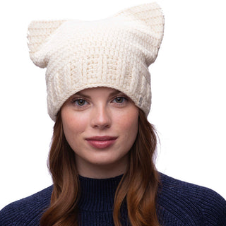 Sentence with Product Name: A woman with auburn hair wearing a handmade knitted cream-colored wool cat ear hat against a white background.