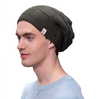 A man wearing a green wool beanie with a checkered slouch pattern.