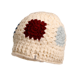 The Crochet Patch Hat features a cream-colored beanie adorned with both a red and a blue circular pattern. This thick-textured beanie includes a small tag at the bottom edge and is showcased against a plain white background.