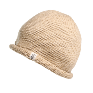 The Baxter Hat, a beige knitted winter beanie with a rolled-up brim, is displayed against a plain white background. Crafted from soft Merino wool, this beanie features a small white tag with an indistinct logo or text.