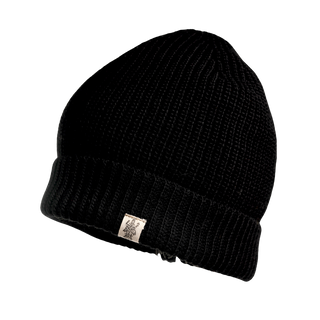 The Bond Hat is a black, knitted winter beanie crafted from Merino wool. It features a small, rectangular fabric tag sewn on the front, and has a ribbed texture with a folded brim. The background is transparent.